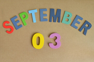 September 3, Toy alphabet with a brown background.