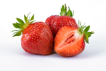 Natural strawberries on a white background. Whole and cut half