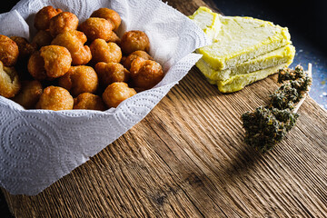 churros balls spanish donuts from medical cannabis butter, sugar, flour, egg. marijuana buds. medical cannabis butter. On a rusty baking sheet. horizontal.