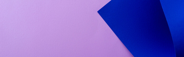 curved blue paper on violet background, panoramic shot