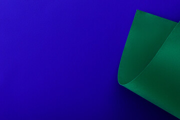 green colorful paper swirl on blue background