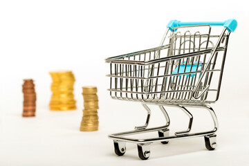 A little shopping cart with gold coins on a white background