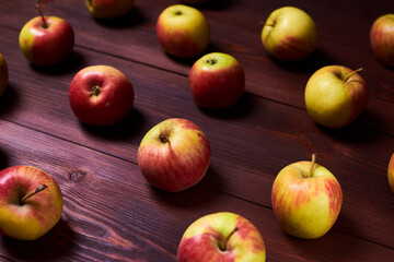 Fresh red-green apples on a wooden background.