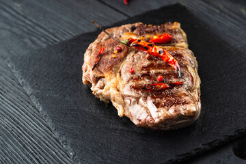 Grilled beef steak with spices on cutting board. Top view