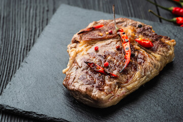 Grilled beef steak with spices on cutting board. Top view