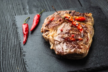 Grilled beef steak with spices on cutting board. Top view