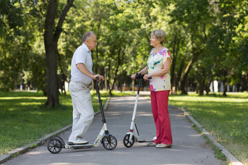 senior couple riding a scooters in the park. Active Seniors