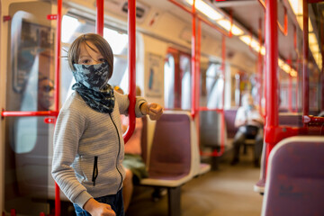 Child, boy, wearing protective mask in underground. Sid in subway in Prague