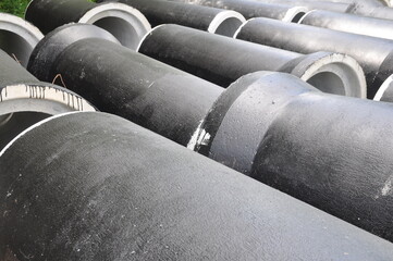 concrete pipes coated with protective mastic at a construction site.