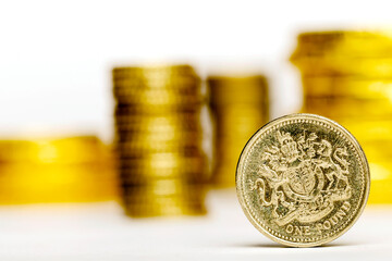 Close up of One British Pound with blurred money on the white background