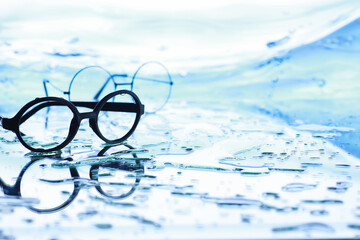 Tools for vision correction. Glasses and lenses with diopters on the background of splashes and...