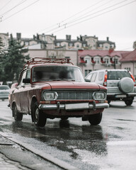 Old red soviet car driving on the streets