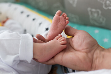 Baby feet in father hands. Tiny Newborn Baby's feet on female Shaped hands closeup. Happy Family concept. Beautiful conceptual image of Maternity