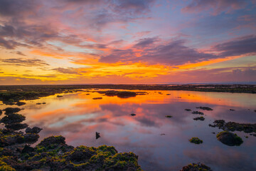 Fototapeta na wymiar Wonderful seascape. Beach at sunset during low tide. Sunset golden hour. Sunlight reflection in water. Colorful sky with clouds. Bingin beach, Bali, Indonesia