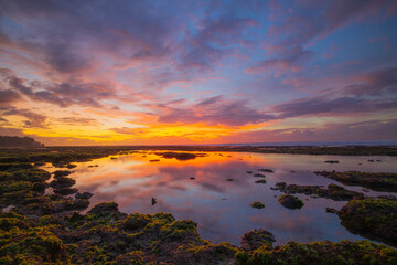 Fototapeta na wymiar Wonderful seascape. Beach at sunset during low tide. Sunset golden hour. Sunlight refletion in water. Colorful sky with clouds. Bingin beach, Bali, Indonesia