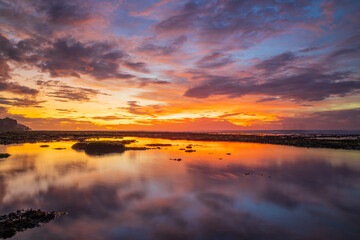 Wonderful seascape. Beach at sunset during low tide. Sunset golden hour. Sunlight reflection in water. Colorful sky with clouds. Bingin beach, Bali, Indonesia