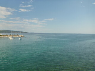 Fototapeta na wymiar Sun rays, turquoise sea water and little boats.