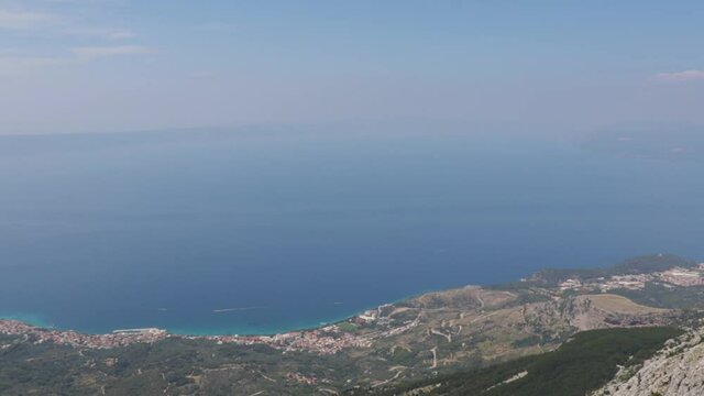 Panning motion, view from the Biokovo skywalk, newly built observation platform. View of the Adriatic sea, Tucepi, Makarska and Podgora towns on the coast