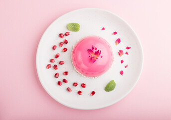 Pink mousse cake with strawberry on a pastel pink background. top view, close up.