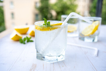 glass of soda water with ice, mint and lemon. refreshing summer cocktail concept with tonic or transparent alcohol