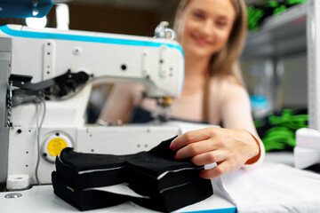 Beautiful female seamstress working with fabric at her workplace