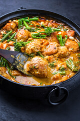 Afrikanisches modern style Krokodil Curry mit Sußkartoffel, Brokkoli und Erdnüsse als close-up in...