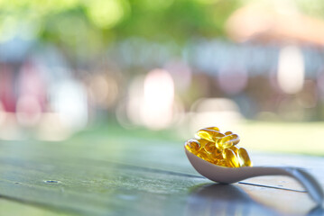 Capsules fish oil omega-3 on a white spoon. Health and beauty concept.