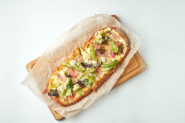 Freshly baked pizza margherita with iceberg lettuce, parmesan, crackers and chicken on a wooden tray on a gray background. Italian Cuisine