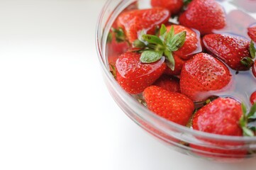 Home strawberry in bowl with water with copy space background . Summer vitamins.
