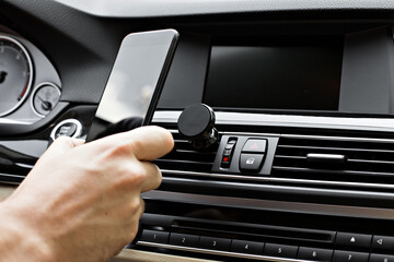 Mobile phone on magnet car mount phone holder for GPS. Lifestyles photo in car. Front view. With...
