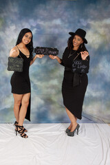 Two black women with a sign that says 