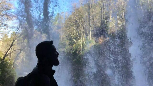 501 Silhouette of a man walking under a waterfall