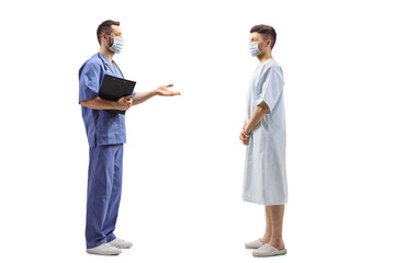 Medical worker with a face mask talking to a young hospitalized patient
