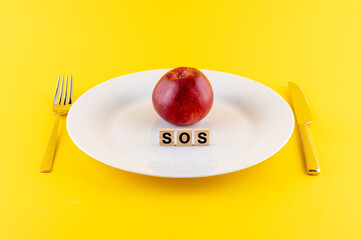 Teller mit einem Apfel und dem Schlagwort SOS