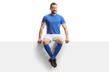 Soccer player sitting on a blank panel