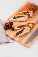 Strudel with poppy seeds on a wooden Board with a knife. Dessert poppy seed roll.