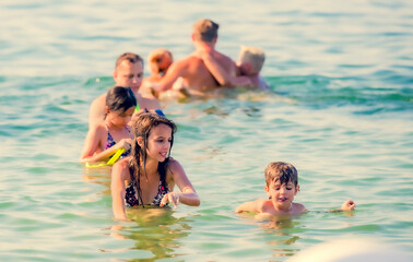 wet dad and daughters swimming in the sea, playing and having fun together on the beach. family vacation. father day.