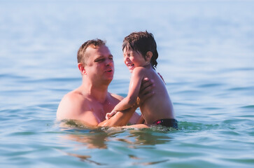 dad with his son are swimming in the sea.Sunny day. Mediterranean Sea.