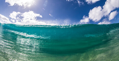 Onda com brilho e textura quebrando com céu azul e sol na costa oeste de Oahu, Hawaii
