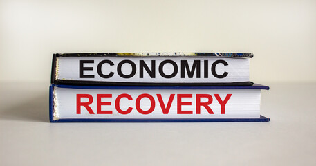 Books with text 'economic recovery' on beautiful white background. Business concept, copy space.