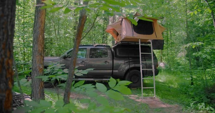 Truck with rooftop tent wild camping in the forest away from rat race of the city