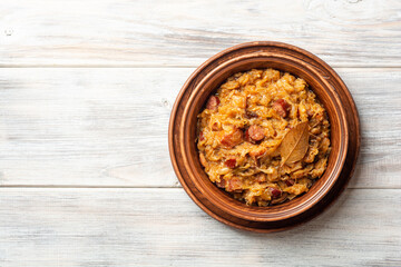 Traditional Polish dish Bigos in ceramic bowl on rustic wooden table