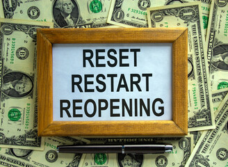 Wooden picture frame with inscription 'reset restart reopening' on beautiful background from dollar...
