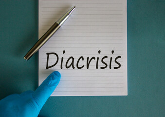 Hand in blue glove, pen, white note with word 'diacrisis'. Medical concept.