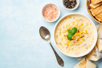 Corn chowder soup in white bowl on concrete background