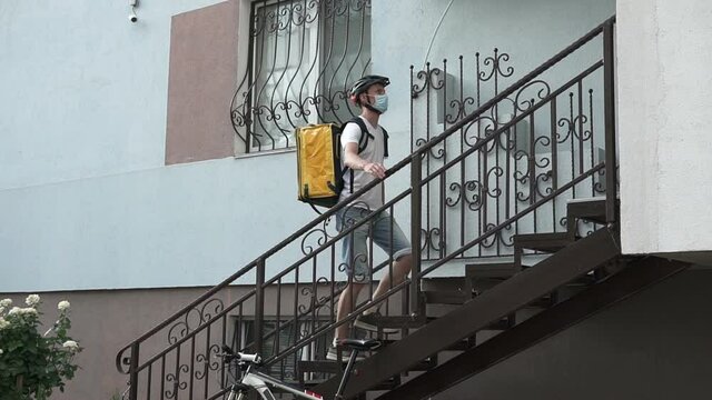 Express delivery to the address on the bike during a viral outbreak. Coronavirus, COVID-19, safe delivery. Slow motion in the frame.