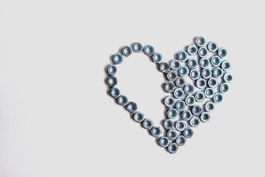 Heart laid out of bolts, nuts on a white background. Father's Day and wedding anniversary concept.