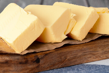 Wooden board with butter on blue checkered napkin