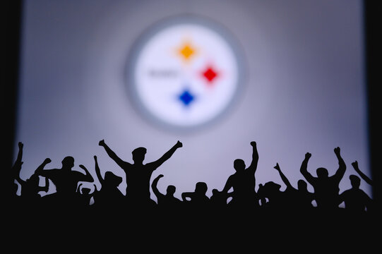 Pittsburgh Steelers. Fans support professional team of American National Foorball League. Silhouette of supporters in foreground. Logo on the big screen.