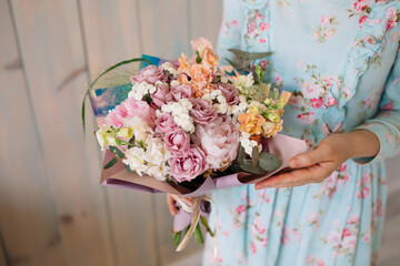 Wedding bouquet at the florist in the hands of roses peonies flowers